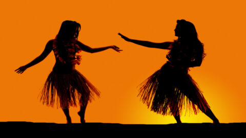 Women dancing at a hula show during a sunset on Kauai