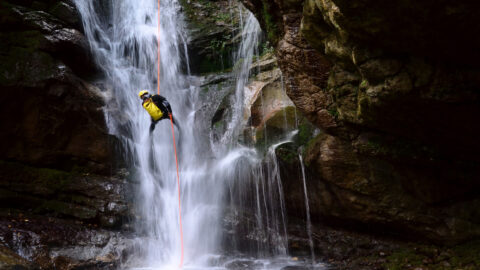 A man rappelling down a waterfall in Kauai